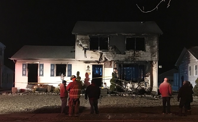 Standing in the street, you can see straight through the burned-out shell of the home. 