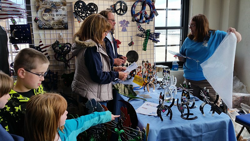 Connie Eckbold waits on customers buying one of the whimsical art pieces created by her son, John Eckbold.