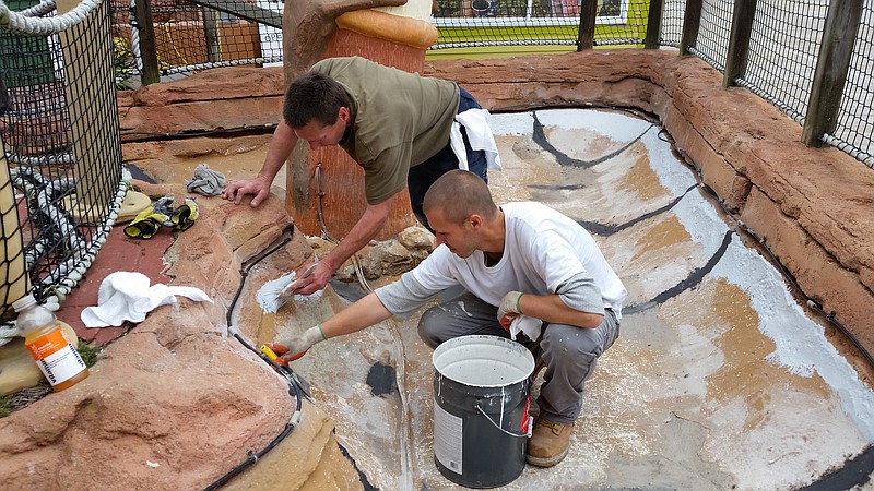 Painters Bill Krzyk, foreground, and Charles Wright do touch-up work on the miniature golf course to get it ready for the summer crowds.