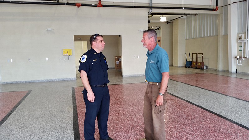 Smith, left, and Straga inspect the area where the fire engines and ambulances will be parked inside the building.