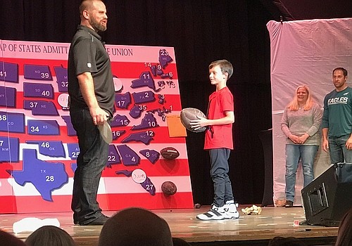 Dorenbos performing a 100% unique trick involving a map and a football with the help of a young fan