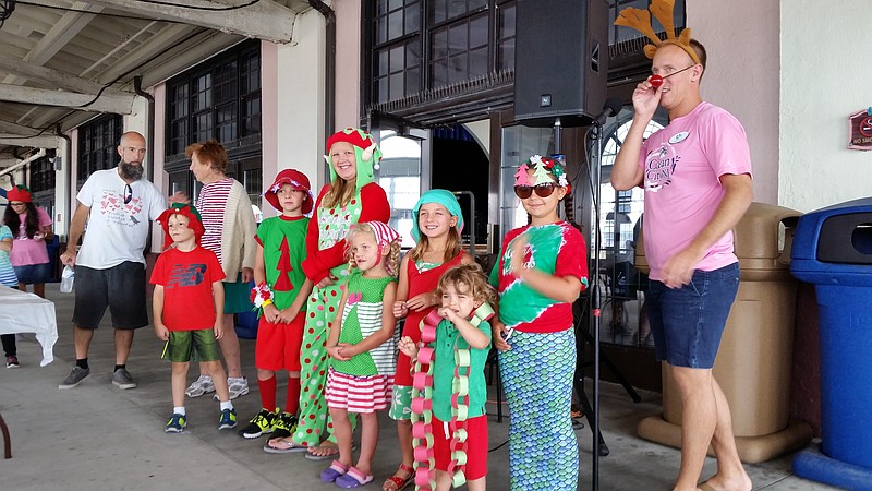 Michael Hartman, right, the city's director of special events, joins with the contestants in a holiday fashion show.