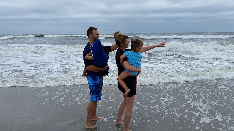 Tim and Chrissy Dorsey, of Easton, Pa., show their children, Kendall and Andersen, the choppy surf.