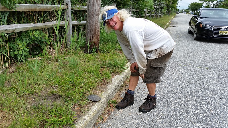 Ocean City landscaper Tim O'Brien stands next to a turtle he rescued from the road at Dory Drive.