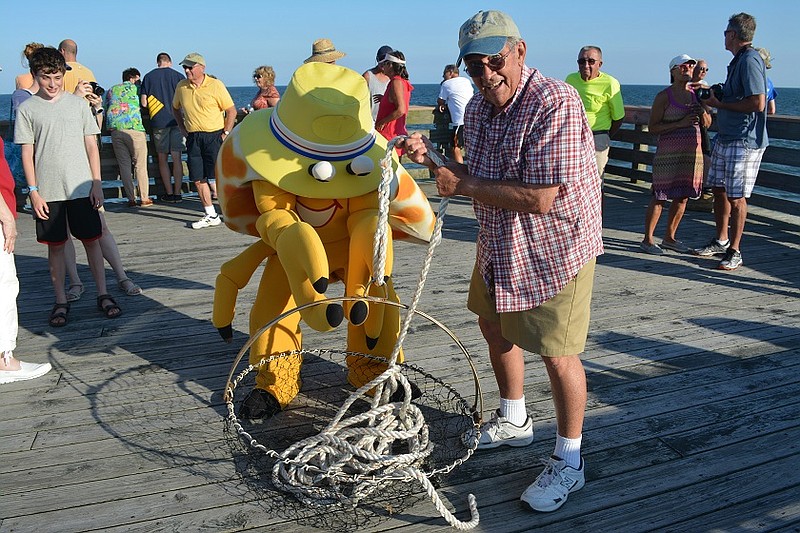 At last year’s Ocean City Fishing Club Open House, member Gene Lindacher, of Ocean City, showed mascot Martin Z. Mollusk how anglers on the pier use a net to haul up the big ones.