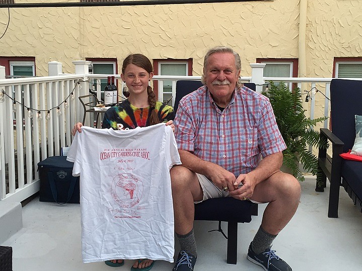 Rich Bennett, from the Ocean City Gardens Civic Association presents Reagan DeVlieger with the first of 500 t-shirts that will display her design. 