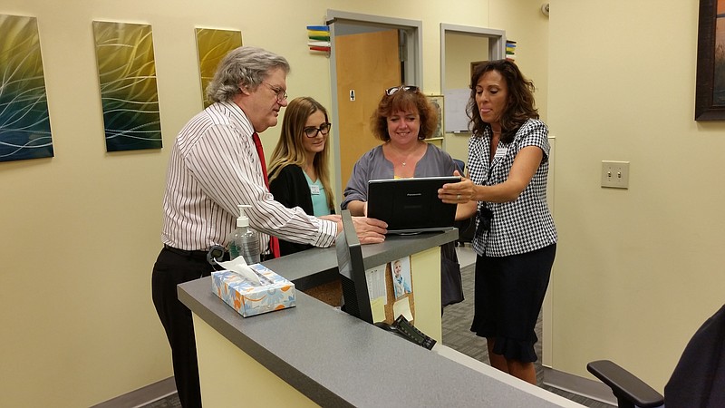 Dr. Roeltgen consults with staff members at the facility. More employees are expected to be added in about six months.