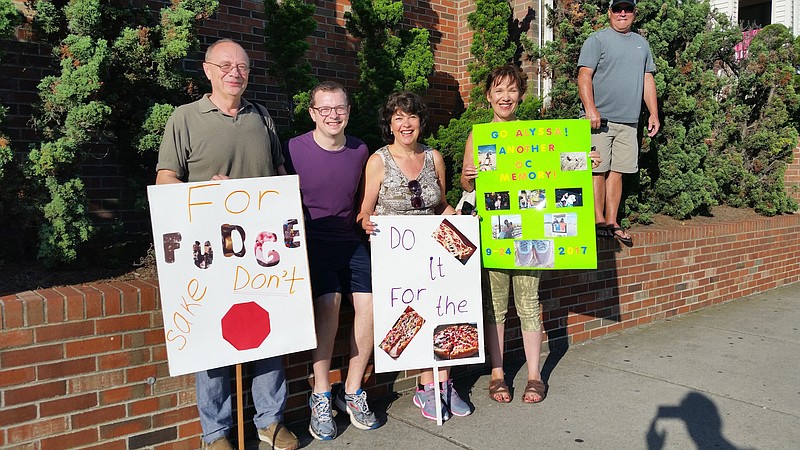 Family members of half-marathoner Alyssa Greenfield, of Princeton, display the comical signs they made to encourage her during the race.