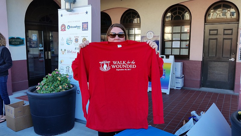 Cami Bonsera, marketing manager for OceanFirst Bank, displays one of the Walk for the Wounded shirts that were given to donators.