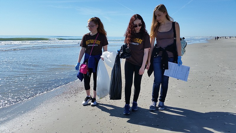 From left, Rowan University students Gianna Hill, Nicole Tota and Gina Yaroli search for litter along the water's edge.