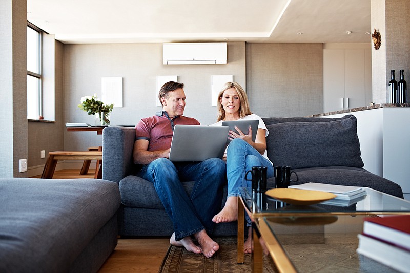 Shot of a mature couple sitting on their sofa using a laptop and digital tablet