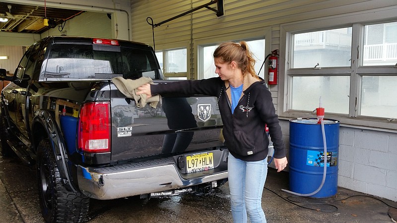 Car Caress employee Holly Owens dries off a pickup truck that was washed at the Ocean City location.