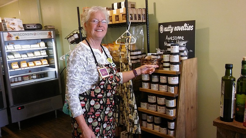 Jackie Dougherty shows a display of peanut butters she sells made by a business owner she met at a farmers market. 