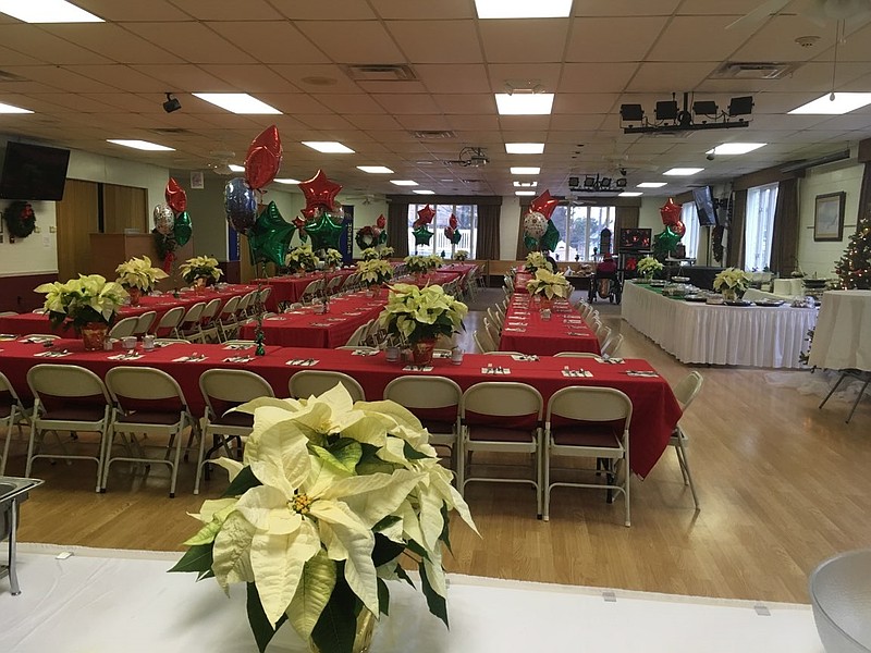 Each table is decorated with a fresh white table cloth and poinsettia centerpieces. 