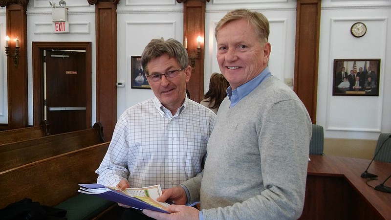 From left, Rick Jones of Universal Media, shows Tourism Commission Chairman Burt Wilkins some plans for city's 2018 media campaign.