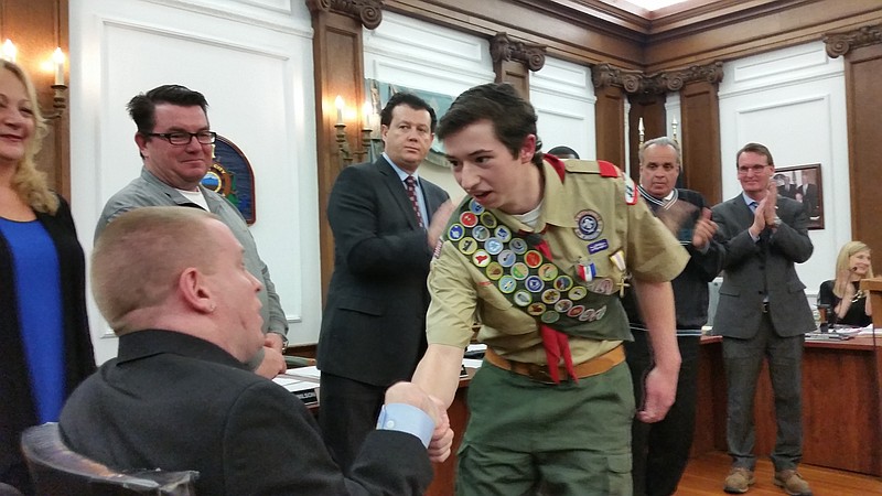 Eagle Scout Nicholas Theis receives congratulations from Councilman Bob Barr as other Council members applaud.