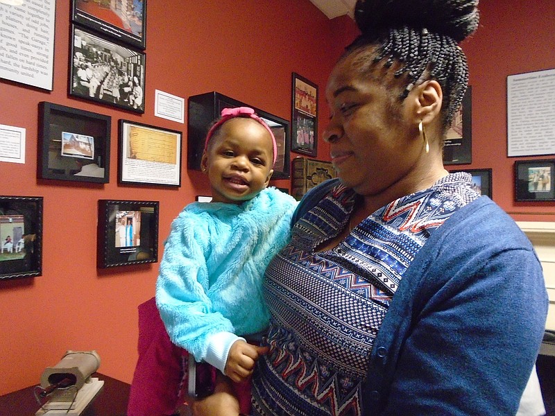 Latoya Wilson, sister of Takiya Wilson, an organizer of the exhibit, with her daughter Bella Bethea, of Absecon, enjoy viewing the photos.