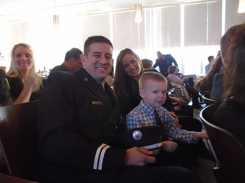 Captain John Quigley Jr. and his wife Kim are all smiles with Luke, 3, at the swearing-in ceremony.