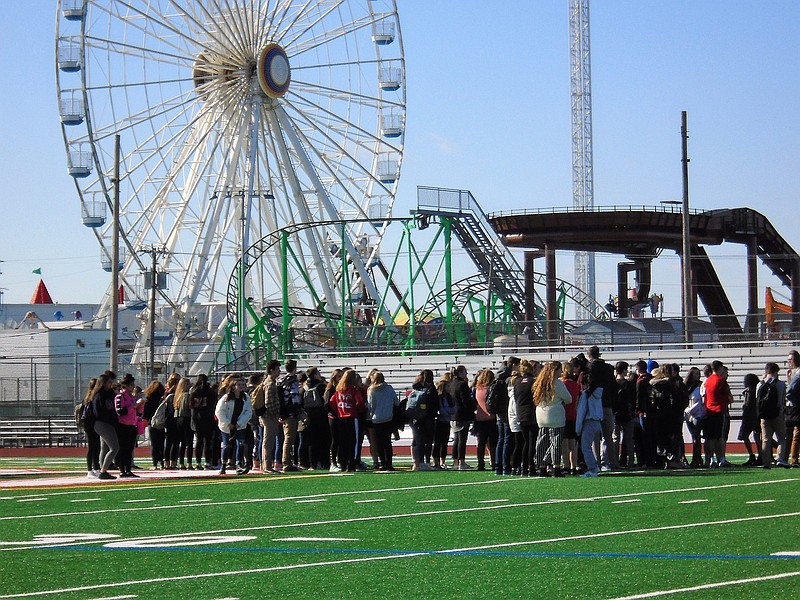 Ocean City High school students face empty bleachers at the football field Wednesday, as they bow their heads in silence for those lost in the Parkland, Fla. mass school shooting, during the National Walkout.