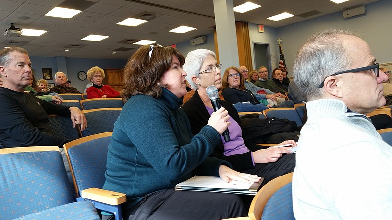 Bark Drive resident Carolyn Logan, holding microphone, tells the mayor it has been a challenge navigating through the construction zone.