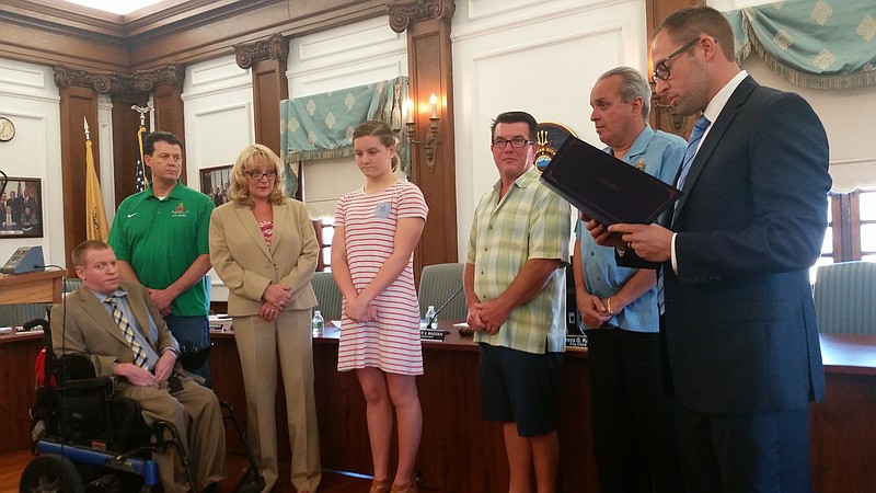 Ocean City High School swimming champion Maggie Wallace, in striped dress, is honored in a proclamation read during the Council meeting.