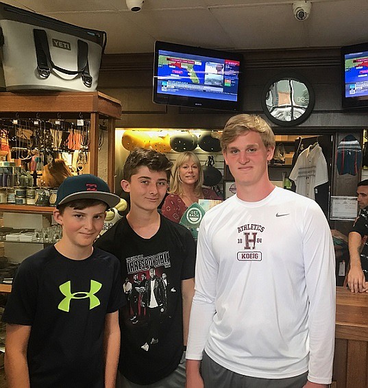 Harry Koenig, Flynn DeVlieger, and Pierre Koenig shown shopping at 7th Street Surf Shop. Becky Friedel said that the shop has been busy all weekend. 