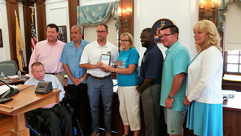 Pam Craighead with City Council holding a plaque she and her husband Jeff Craighead presented to council to show appreciation for supporting Bike MS.