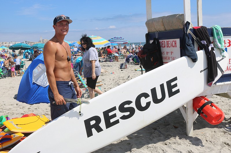 Derek Kneisel shows off a rescue board like the one he used last July to rescue a father and son in the surf.  