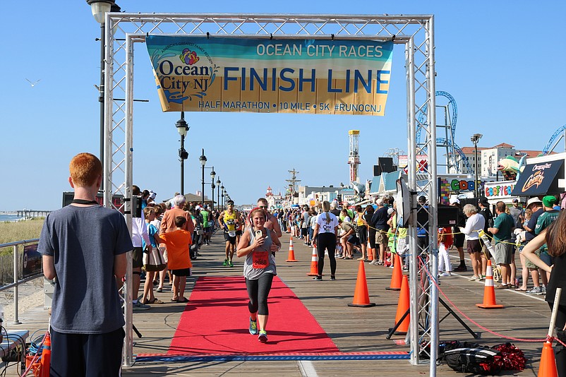 Sacena Veasey, 34, of Leesburg in Cumberland County, crosses the finish line in the half marathon.