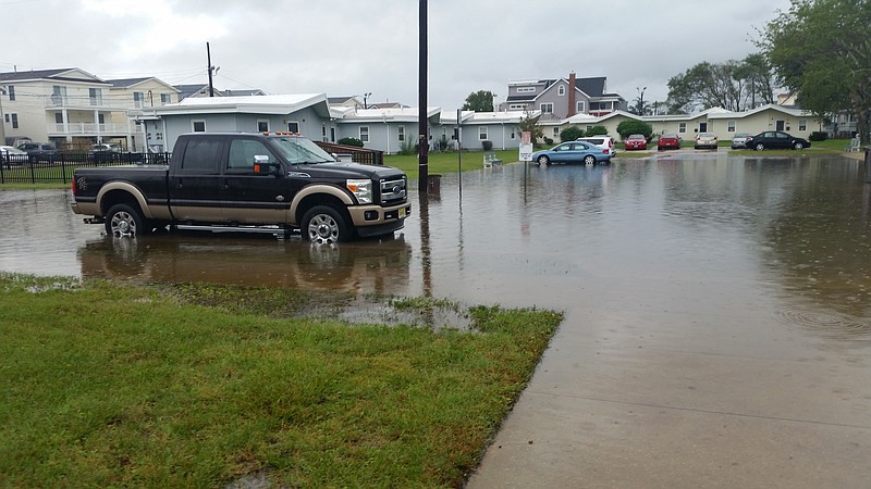 Rising storm water spreads from Fourth Street into the parking lot of the Pecks Beach Village complex in the background during a storm in September.