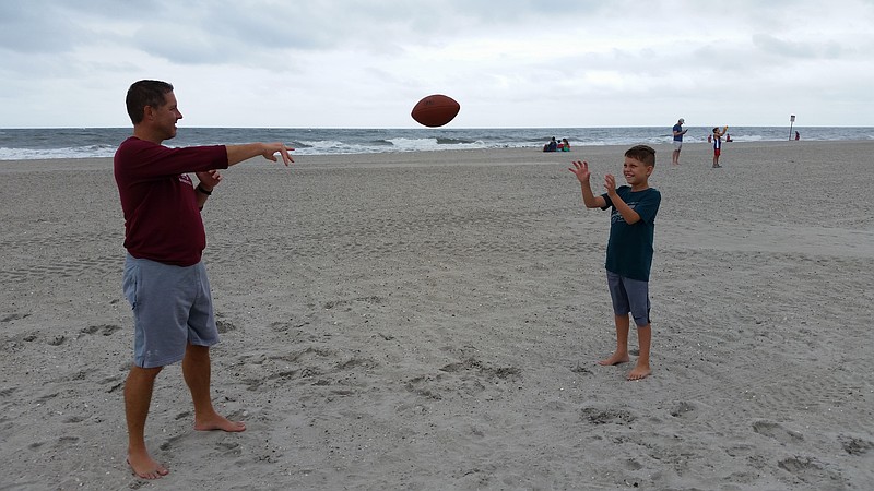 Tom Fithian, of Newtown, Pa., and his son, Chase, play a game of catch on a quiet beach near Surf Road in the north end of town.