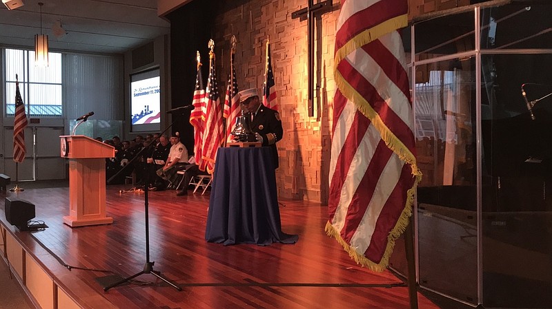 Ocean City Fire Chief James Smith performs the "Striking of the Four Fives," a longstanding tradition to recognize a fallen comrade.