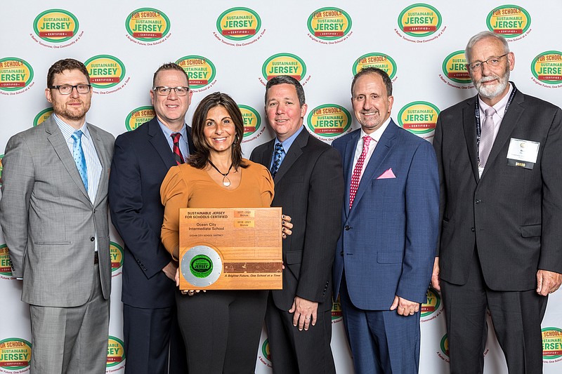 Intermediate School Principal Geoffrey Haines (second in on right) with officials as he receives the bronze certification for sustainability in October. (Photo courtesy JASM Consulting)