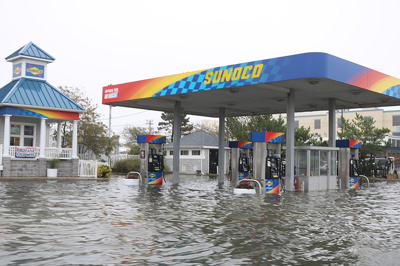 Stormwater swamps the gas pumps at a Sunoco station on Ninth Street during the height of flooding Saturday morning.