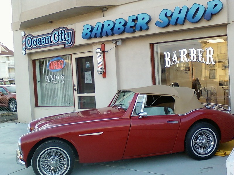 A vintage 1962 Austin-Healey convertible graces the outside of the barber shop.