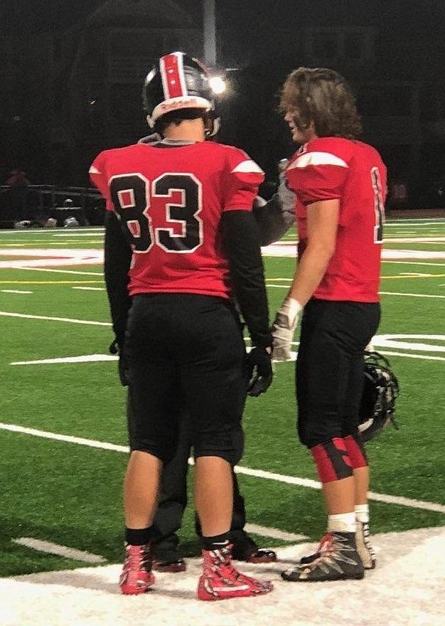 Austin Green (83) and Travis Stoerrie have a word before the Mainland game. 