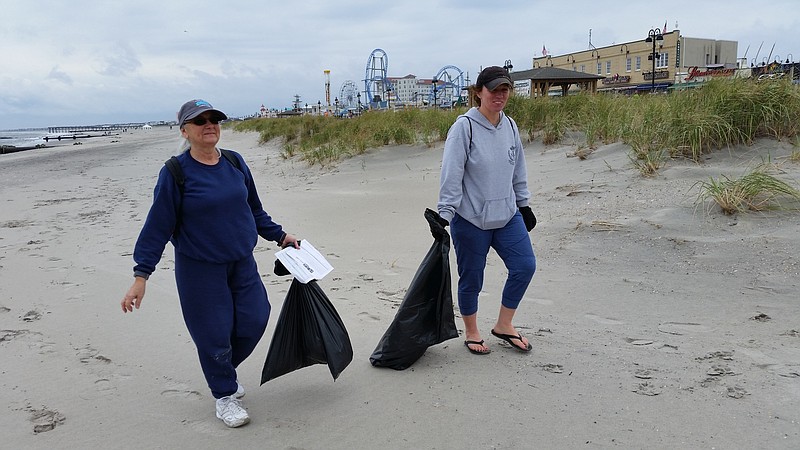 Valerie Tedesco, left, and Diana Wiseman search the beach and dunes for trash during the cleanup in 2018.