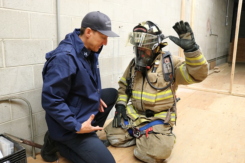 Capt. Ray Clark, left, who is in charge of the fire department's training, checks Dave Martin's safety gear in 2018.