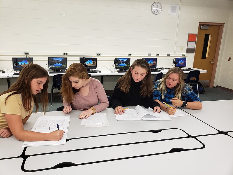 Left to right: Eighth grade students Julia Newman, Eva McKnight, Ellie, Kutschera, and Laney Michael work together on their crystallization project to submit as part of the Student Spaceflight Experiments Program. 