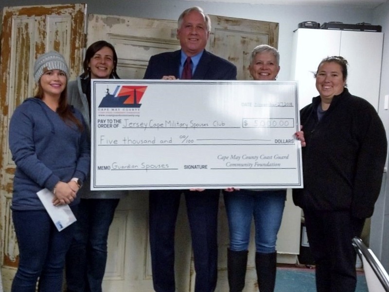 Mike Couch, executive director of the Cape May County Coast Guard Community Foundation, presents a $5,000 donation to Jersey Cape Military Spouses' Club members (from left) Brittany Hencken, Lisa Harczak, Kathy Gibbons and Ashley Andel.