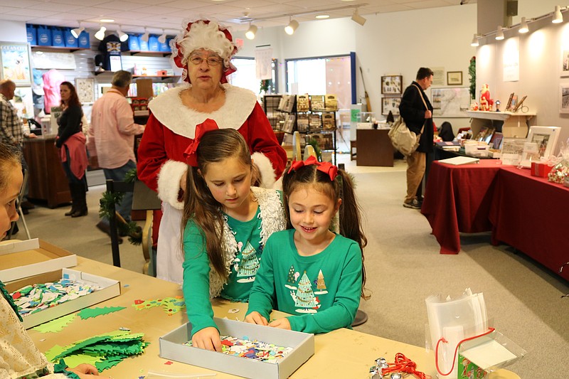 Mrs. Clause helps sisters, Mckenna, 7, left, and Gianna, 5, Garvey of Egg Harbor Township with their crafts.