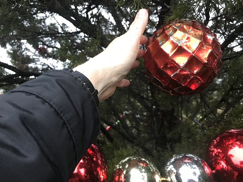 The tree is adorned with an assortment of decorations, including large ornaments.