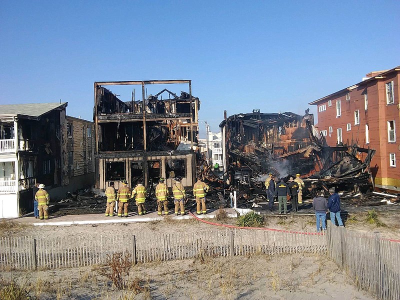 Firefighters look at the charred remains of two duplexes on the 4800 block of Central Avenue.