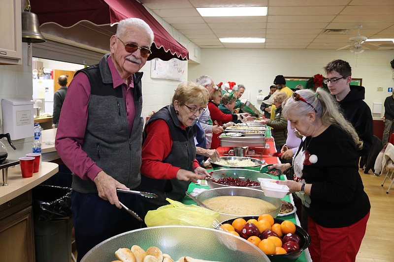 John Quinn, of Ocean City, and his wife Marty, alongside him, serve up Christmas dinner at St. Peter's United Methodist Church in 2018.