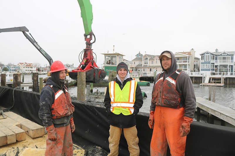 Caleb Rosina, center, a worker with Ocean City's dredging consultant, ACT Engineers, joins with Scarborough Marine employees Steve Schaffer, left and Josh "Doc" Dougherty.