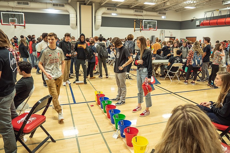 Buckets are lined up on the floor of the high school gymnasium to test out one of the math-inspired games.