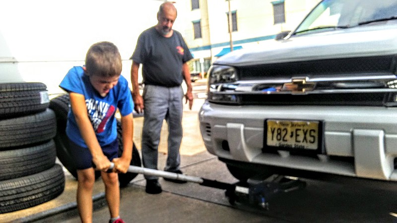 Don Wiesenthal watches as grandson Noah jacks up a car.