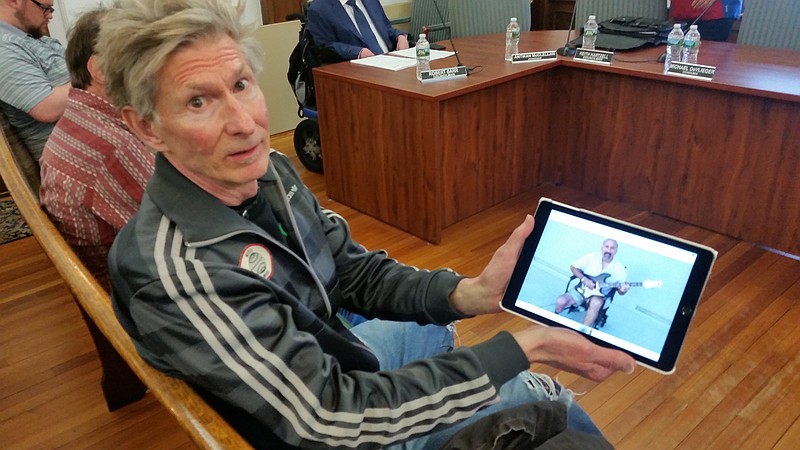 Chris Leibrandt, owner of the Grass Roots Music Shop in Ocean City, displays the picture of a disabled musician who he is worried may not be able to play his electric guitar on the Boardwalk anymore.