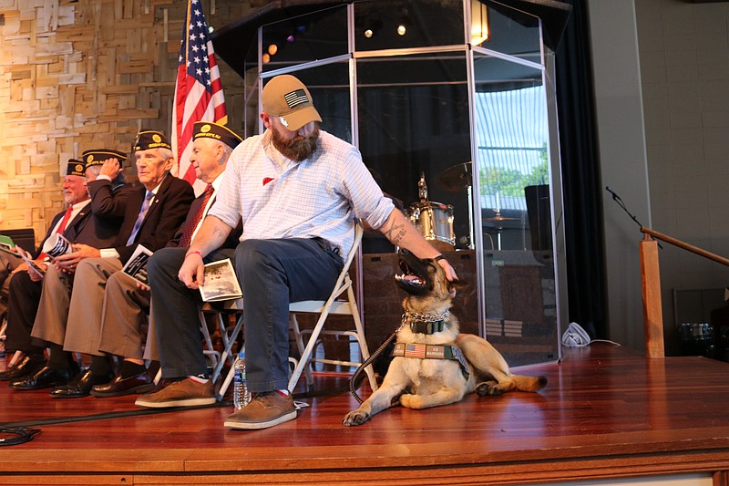 Army Staff Sergeant Patrick Carney gives his K9 companion, Henry, a reassuring pat.