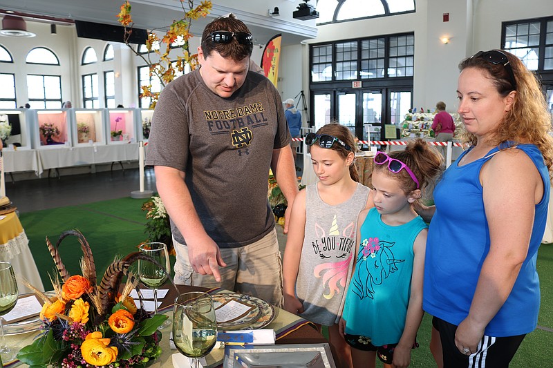 Mike and Angie Patterson, of Medford, and their daughters  Kailey, 9, (left) and Ava, 7, view the Thanksgiving centerpieces.